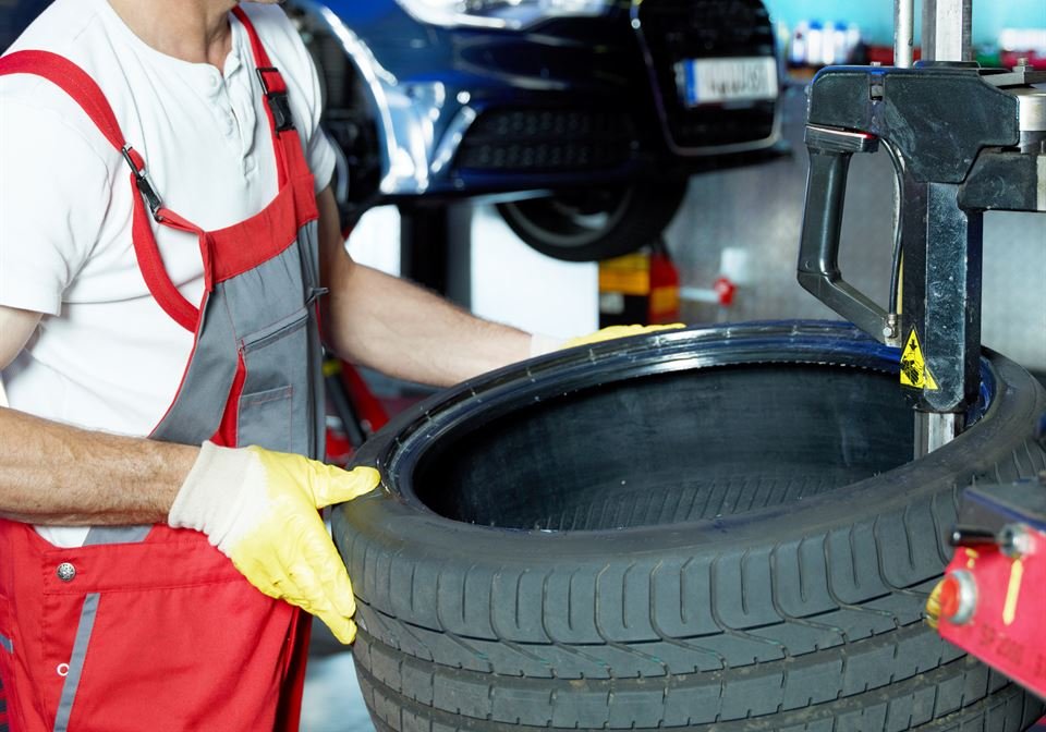 Mechaniker montiert einen Reifen an der Reifenmontiermaschine